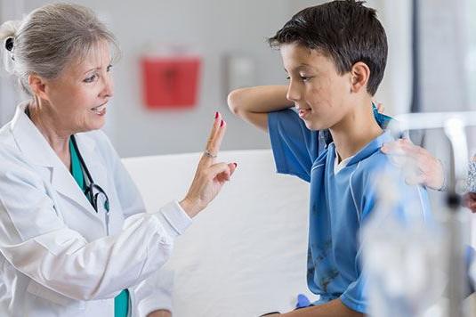 A doctor holding her fingers up for a child to look at